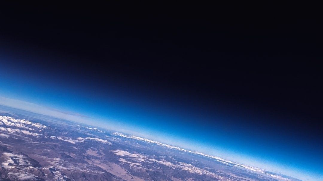 Gebogene Erde mit Wolken und Landschaft unter tiefblauem Weltraum
